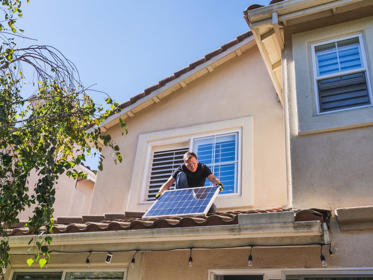 contact-img-02 Solar technician installing photovoltaic panels on a sunny rooftop.